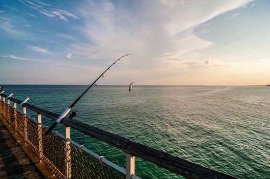 fishing of an ocean pier at sunset in gulf of mexico