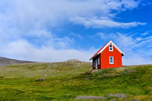 Beautiful red house against the blue sky in Iceland.