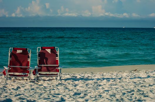 two chairs on a beach with gulf of mexico background