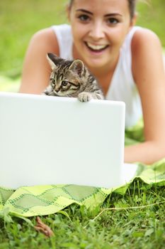 Beautiful girl with her kitty and laptop outdoors