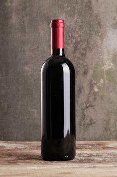 Red wine bottle on wooden background