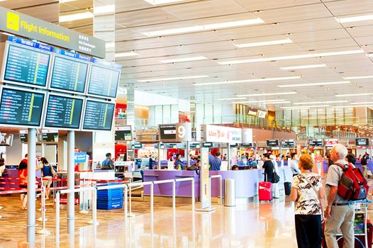 Singapore, Republic of Singapore - March 05, 2013: People looking at depature arrival board at Changi International Airport . Changi Airport serves more than 100 airlines operating 6,100 weekly flights connecting Singapore to over 220 cities