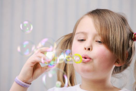 Portrait of a little girll blowing bubbles