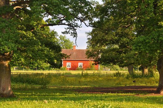 Idyllic cottage with trees and meadows.