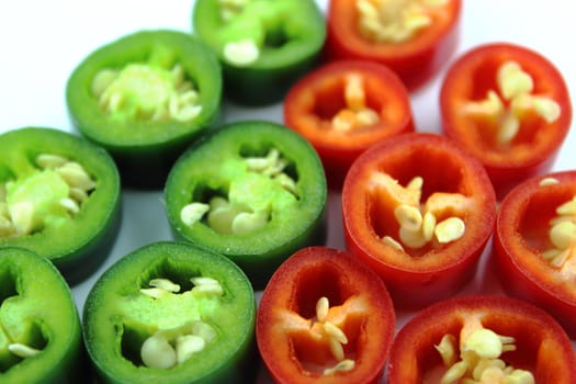 red and green hot chili pepper slices on a white background