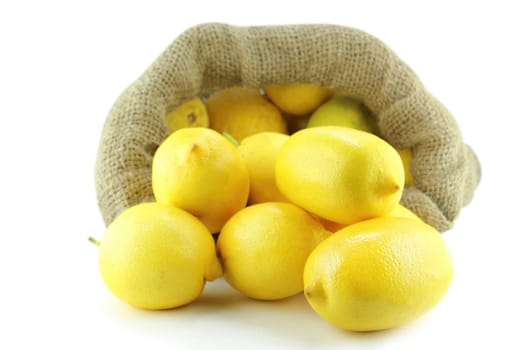yellow ripe lemon out of Sackcloth bag over the orange background with a clipping path