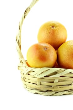 Ripe appetizing grapefruit in straw basket .