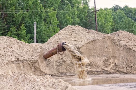 Dirty water flows from a pipe. Toxic production wastes