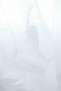 a beautiful young girl sitting behind a white tulle