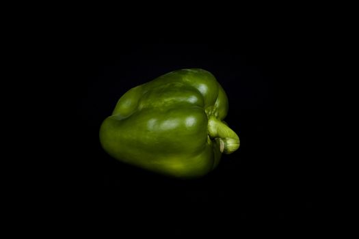 green pepper isolated on a black background