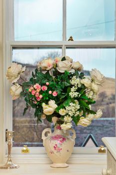 Vase of roses on a window sill