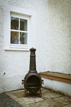 A metal chiminea in a cottage garden