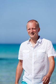 young man walking on the beach in summer holiday vacation