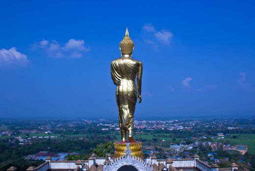 Black golden buddha statue against blue sky in thai temple