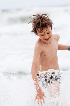 young little boy in water summer holiday having fun sea ocean 