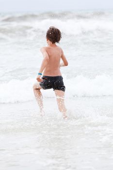 young little boy in water summer holiday having fun sea ocean 