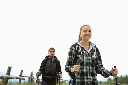 Young couple enjoying a nordic walk, woman is smiling