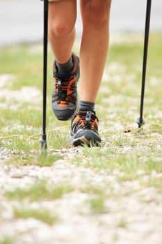 Woman hiking and nordic walking in forest. Sport shoe close up