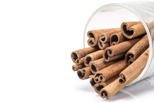Cinnamon sticks in a glass bottle isolated over a white background