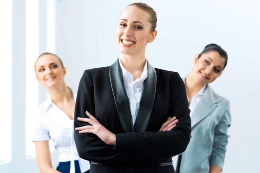 successful business woman in the office, colleagues stare over his shoulder