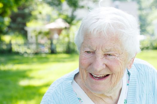 Portrait of a senior woman smiling in a blue sweater outside