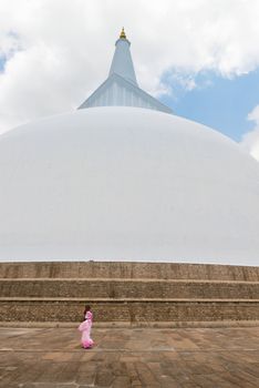 Woman in sari go round 103 m high white sacred stupa Ruwanmalisaya dagoba on Apr 16, 2013 in Anuradhapura, Sri Lanka