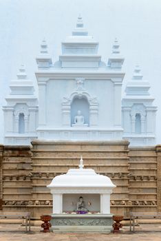 Temple with Buddha image statues near white sacred stupa Ruwanmalisaya dagoba, Anuradhapura, Sri Lanka
