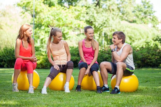 Young caucasians working out in a park with fitness balls