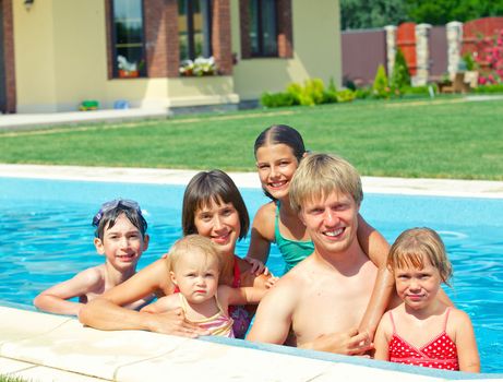 Summer vacation. Happy family with four kids in swimming pool outdoors