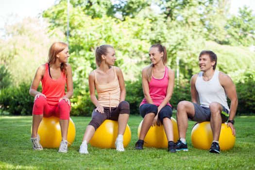 Young caucasians working out in a park with fitness balls