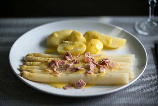 fresh white asparagus with potatoes, sauce hollandaise and ham