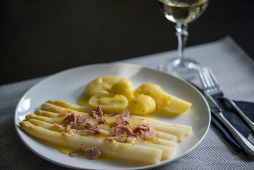 fresh white asparagus with potatoes, sauce hollandaise and ham