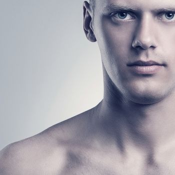 Portrait of naked handsome man over grey background