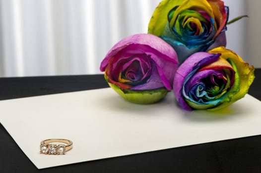 a  roses and wedding rings on white background