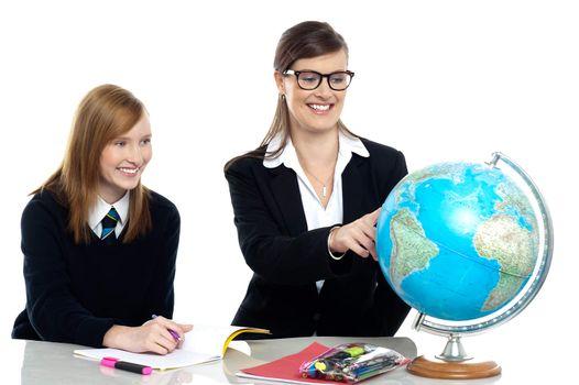 Teacher pointing out a country on the globe