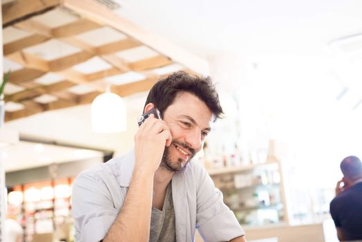 man at the bar on the phone in the morning