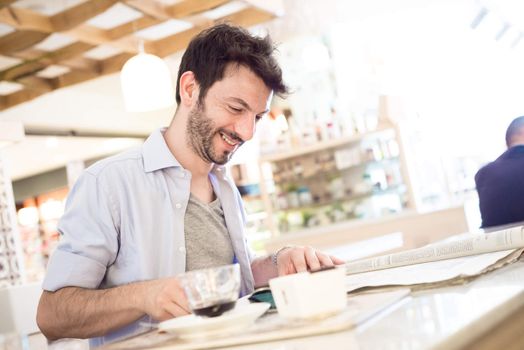 man at the bar reading newspaper in the morning