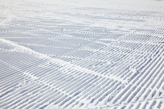 Ski tracks on a fresh groomed piste
