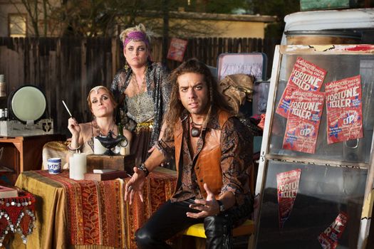 Angry man at table with female fortune tellers