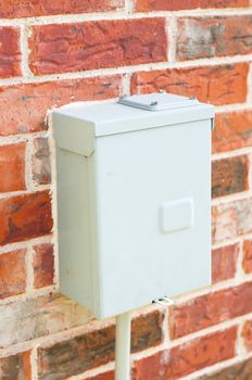 Electricity control box on a red brick wall