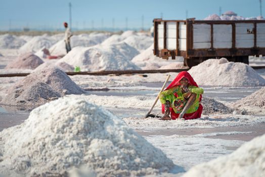 Sambhar Salt Lake, India - Nov 19: Female worker rests in salt farm on Nov 19, 2012 in Sambhar Salt Lake, India. It is India's largest saline lake and where salt has been farmed for a thousand years. 