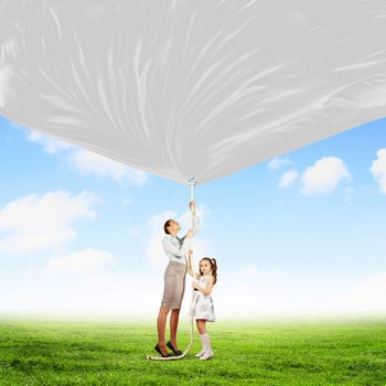 Image of young happy family pulling blank banner