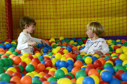little happy kids playing with colored balls
