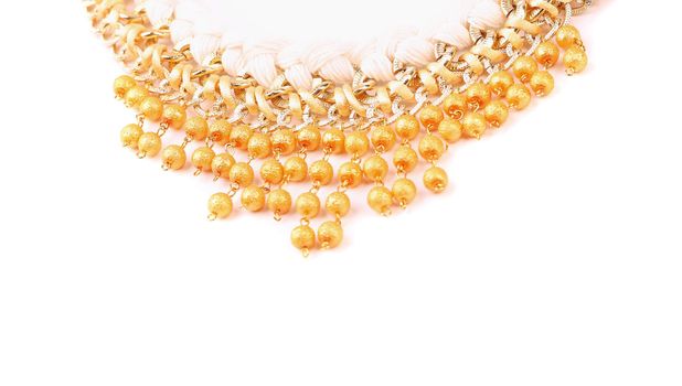necklace of gold pearls on a white bacground