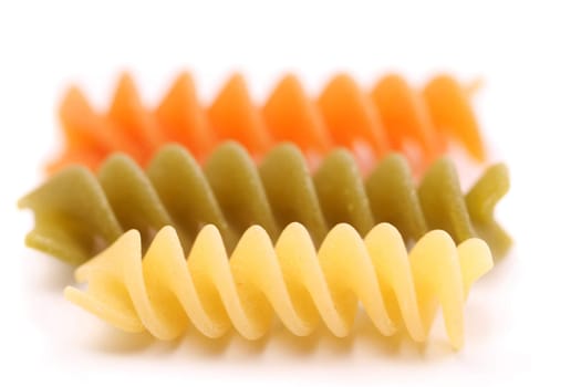 Close-up pasta eliche tricolori are located on the white background.