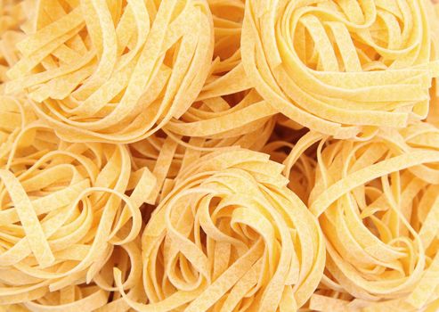 Yellow pasta fettuccine on a whole background