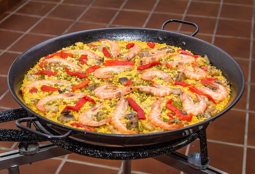 Closeup of traditional spanish paella cooked in a pan, with yellow rice and seafood