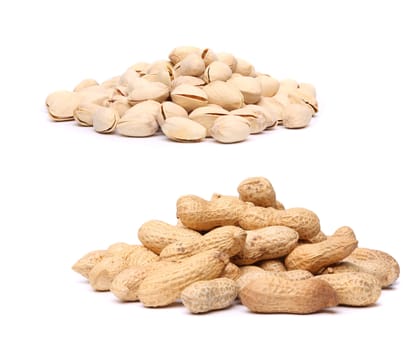 A bunch of pistachios and a bunch of peanuts on the white background.