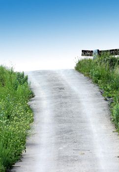 Road on the heaven. Dirt road. Green grass. Blue sky.