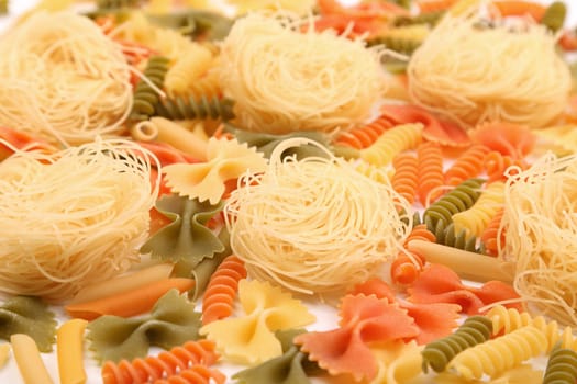 A different pasta in three colors close-up on the white background.